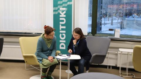 An employee of the library&#039;s digital support guiding another person in the main library Metso.