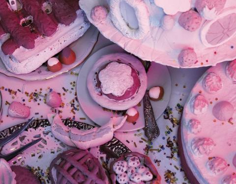 Installaatiossa on vaalenanpunaisia herkkuja kuten kakkuja ja leivoksia.
