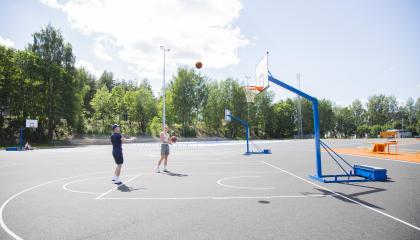 Two men throw the ball into the basket.