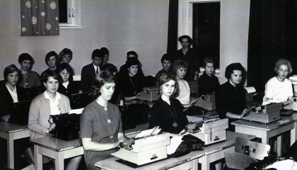 Opiskelijat opiskelevat pulpeteilla konekirjoitusta.