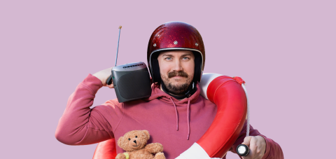 A bearded man with a helmet on, a radio on his shoulder and a life ring around his neck.