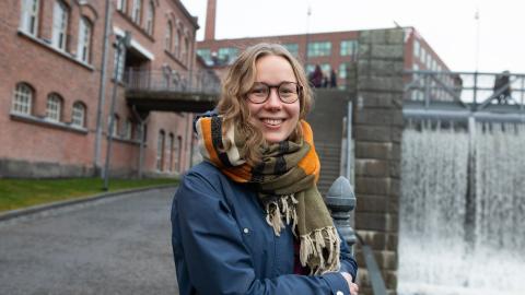 Olivia hymyilee kameralle Tammerkosken edessä.