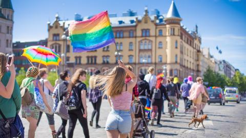People with rainbow flags walking in Tampere.