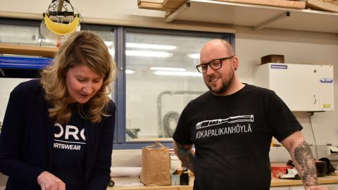 Kaksi henkilöä puukäsityöluokassa talttatyössä.