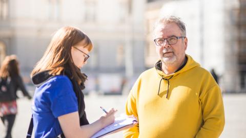 An employee of the city of Tampere interviews a resident on the street.