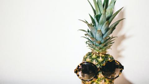 Kuvassa on ananas, jolla on aurinkolasit