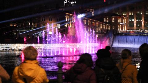 Värivaloin koristeltu Tanssivat vedet -suihkulähde-esitys Tammerkoskessa syysiltana.
