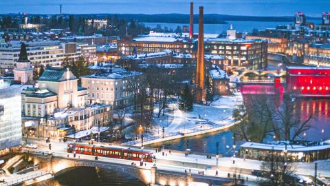 Hämeensiltaa ylittävä raitiovaunu ja talvista Tampereen keskustaa ilmasta nähtynä.