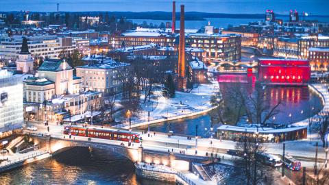 Talvinen iltavalaistus Tampereen keskustasta, jossa etualalla Hämeensilta, ratikka, Tammerkoski ja takana häämöttää Näsijärvi.
