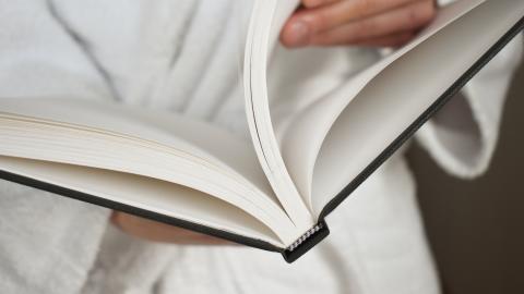 The person is holding an open book.