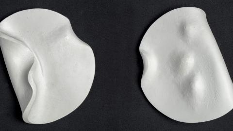 Kaksi pyöreää valkoista mitalia, joissa pehmeitä kohoumia.