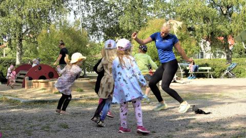 Lapset tanssivat leikkipuistossa liikunnanohjaajan kanssa.
