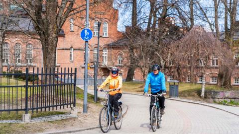Kaksi pyöräilijää keväällä pyörätiellä Frenckellin edustalla.