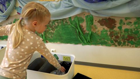 A little girl sorts rubbish in a daycare centre