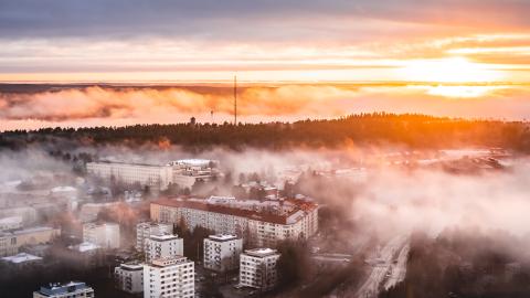 Punertava auringonlasku sumuisena syysiltana Tampereen yllä.