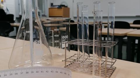 Kuva koulun kemian luokasta ja työvälineistä kuten esim. koeputkista.