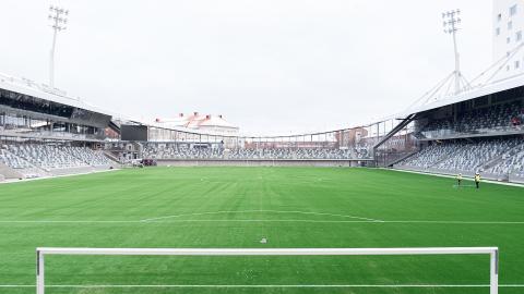 Tammelan jalkapallostadionin vihreää tekonurmikenttää reunustavat katsomot.
