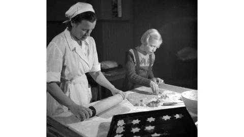 Nainen ja lapsi leipovat piparkakkuja.