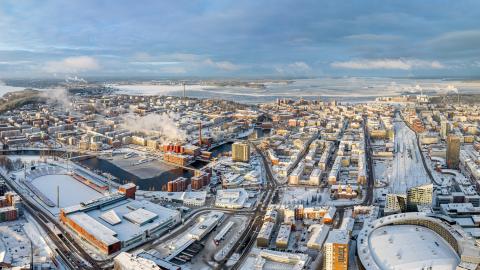 Ilmakuva talvisesta Tampereen kaupungin keskustasta ja taustalla sininen taivas.