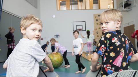 Lapset harjoittelevat sirkustemppuja jumppasalissa.