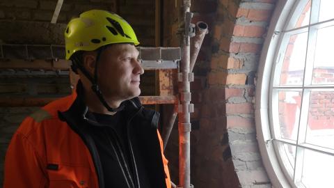 Opiskelija työvaatteissa rakennustyömaalla.