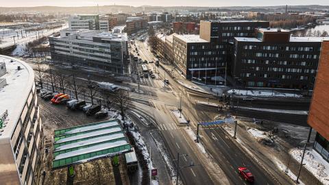 Junction of Hatanpää highway and Tampere highway, looking south. Cars at the intersection and in a parking lot.