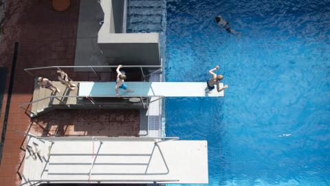 Children on the diving board at Outdoor swimming pool.