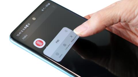 Käsi pitämässä puhelinta, jonka näytöllä PIKI-sovellus. 