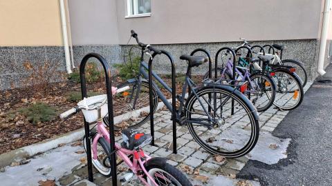 Polkupyöriä telineessä kerrostalon pihassa.