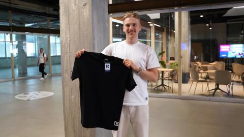 Nuori mies, Tommi Riikonen, esittelee Kaius-paitaa.