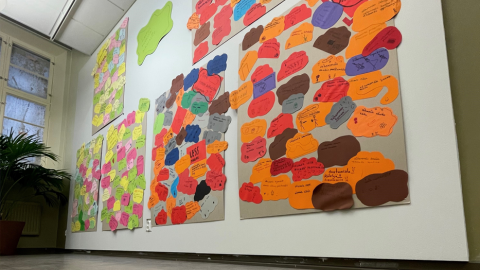 Valkoisella seinällä kuusi isoa teosta, joissa lasten kirjoittamia viestejä eri värisille lapuille.