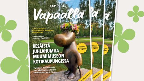 Kolme kesän 2025 Vapaalla-lehteä pinossa, taustalla graafisia neliapiloita. Lehden kannessa on pronssinen muumipeikko-patsas.