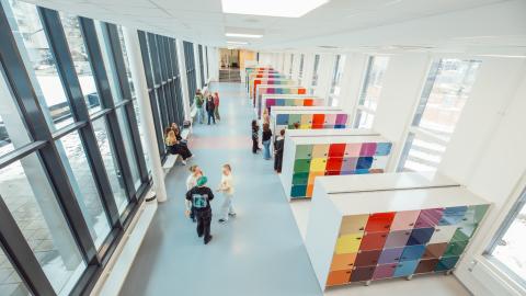 Lukiolaisia koulun käytävällä seisomassa.