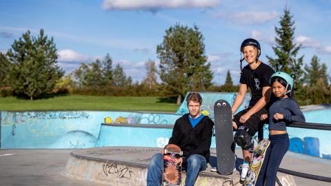 Kolme nuorta skeittirampilla. Yhdellä skeittilaudalla on silmät.