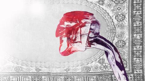 Grafiikan teoksessa on taustalla harmaa matto ja edessä pitkäkaulainen hahmo punainen naamio päässään.