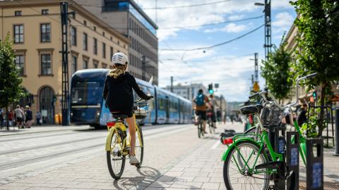 Cyclists on Hämeenkatu, a tram running in the background.