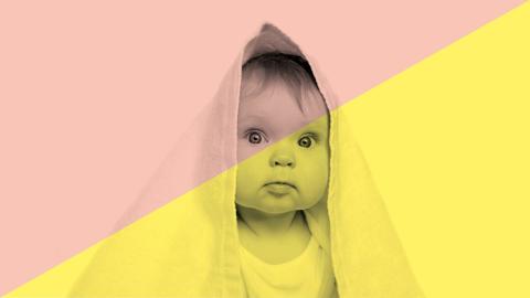 Vauva, jolla päänsä päällä pyyhe huppuna.