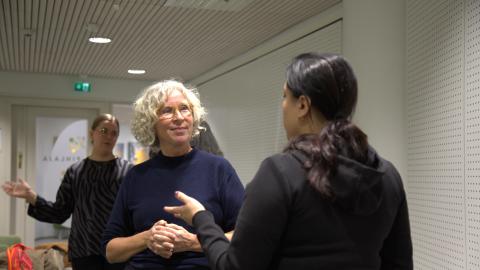 Vaalea- ja tummahiuksinen nainen keskustelevat. 