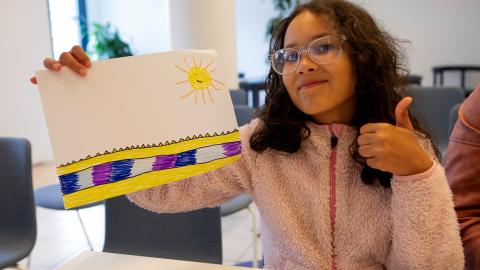 Nuori näyttää piirustustaan kameralle.