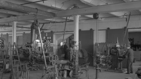 Paja, jossa on koneita ja ihmiset työskentelevät niiden ympärillä.