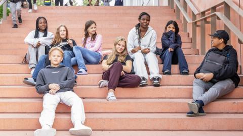 nuoria istumassa koulun rappusilla