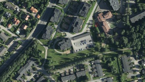 Ilmakuvassa paljon vihreää ja puita, taloja ja katuja.