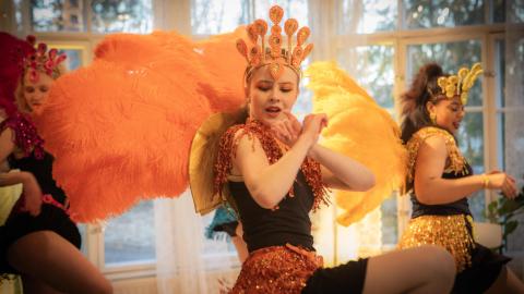 Kolme sambaajaa tanssivat värikkäissä puvuissaan.