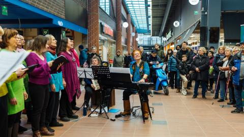Kuoro esiintyy kauppakeskuksen aulassa.