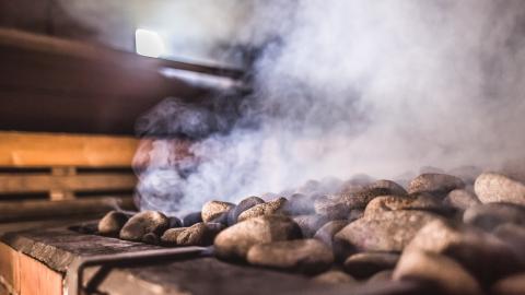 Saunan kiukaan kivet höyryävät.