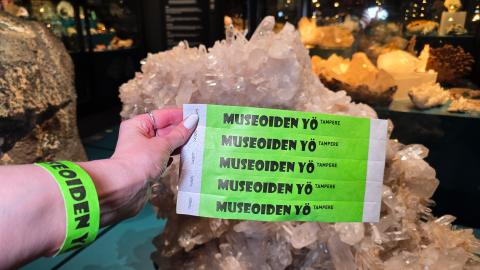 Green Night of Museums wristbands on person's hand.