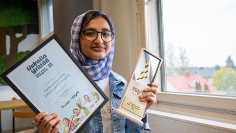Hasanat Sultani presents her two prizes in a classroom at Hatanpää school.