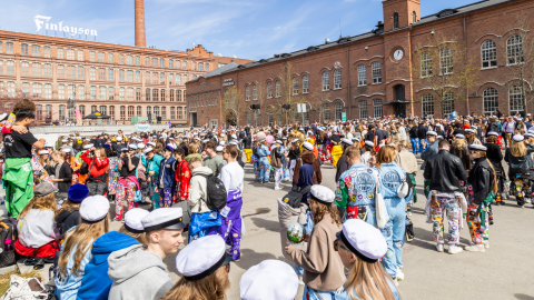Satoja opiskelijoita koolla Frenckellin aukiolla vapputapahtumassa ylioppilaslakit päässään ja haalarit yllään.