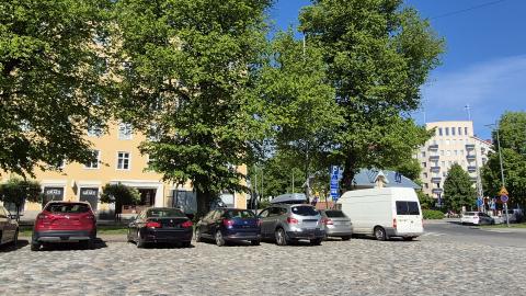 Pyynikintorin nupukivinen parkkipaikka isojen puiden edessä kesällä.