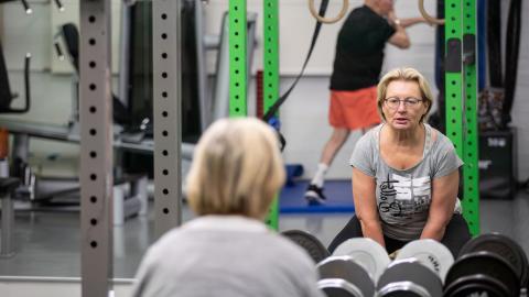 A woman is lifting weights at the gym.